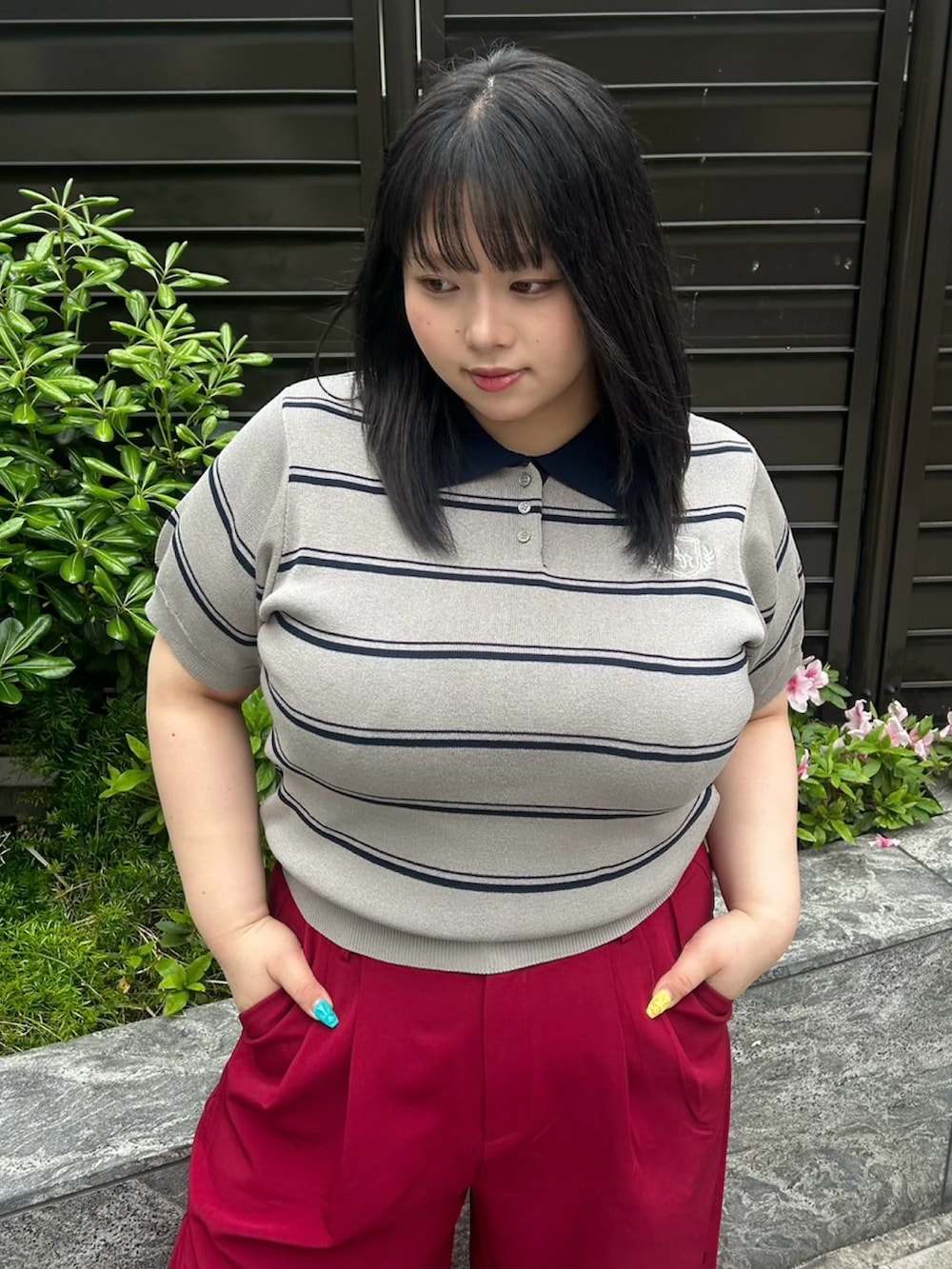 レッド系のその他パンツ、グレー系のポロシャツを着用したレディースの春コーディネートの4枚目の写真
