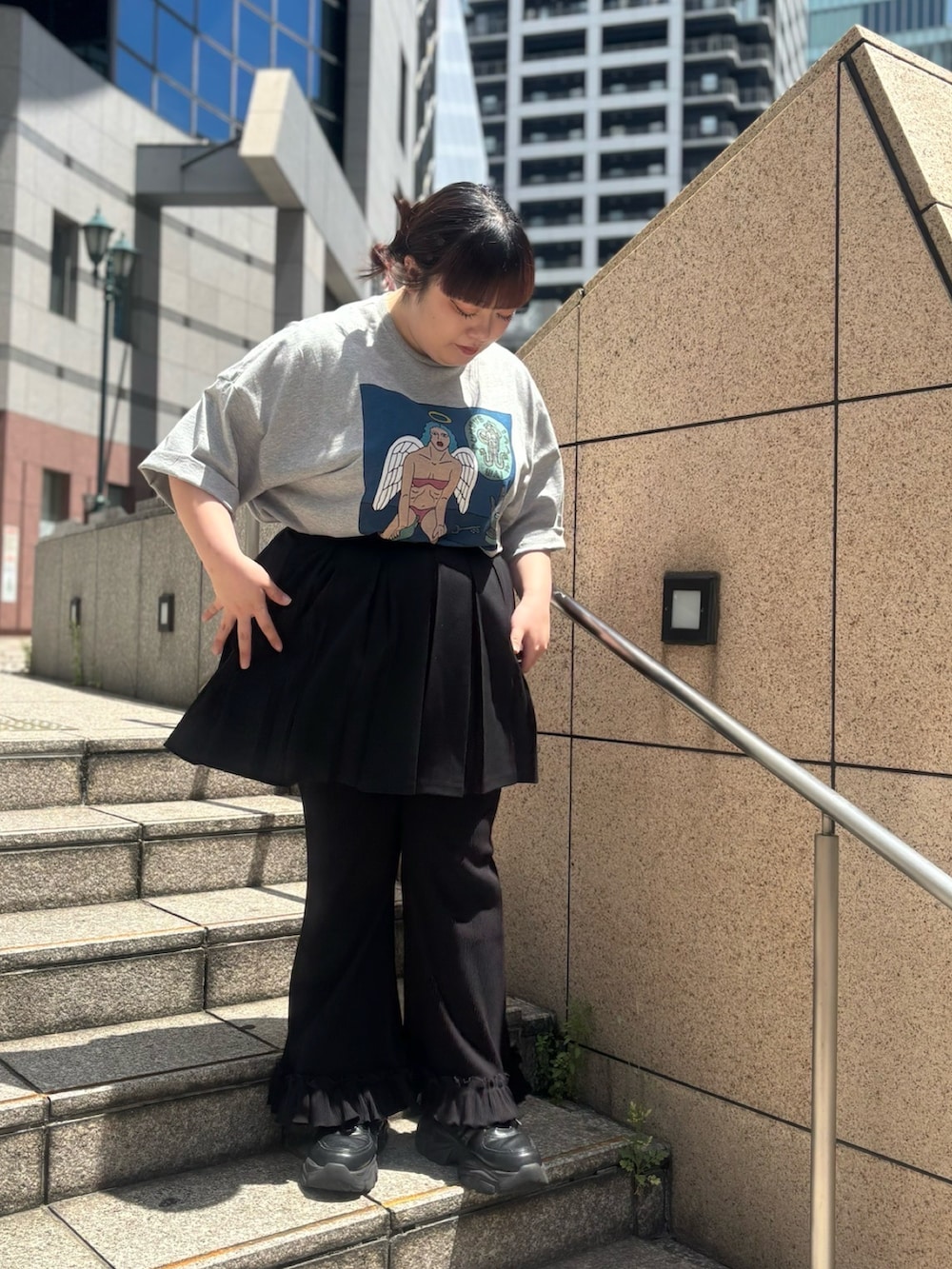 ブラック系のスカート、グレー系のTシャツ/カットソー、ブラック系のその他パンツを着用したレディースの春コーディネートの2枚目の写真