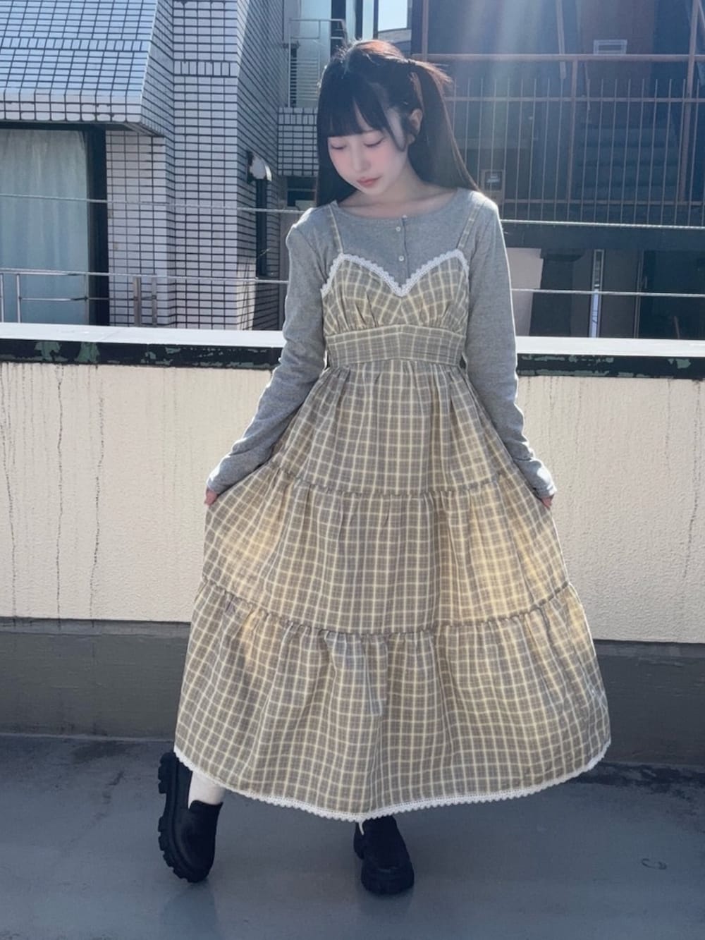 イエロー系のワンピース、グレー系のカーディガン/ボレロを着用したレディースの春コーディネートの3枚目の写真