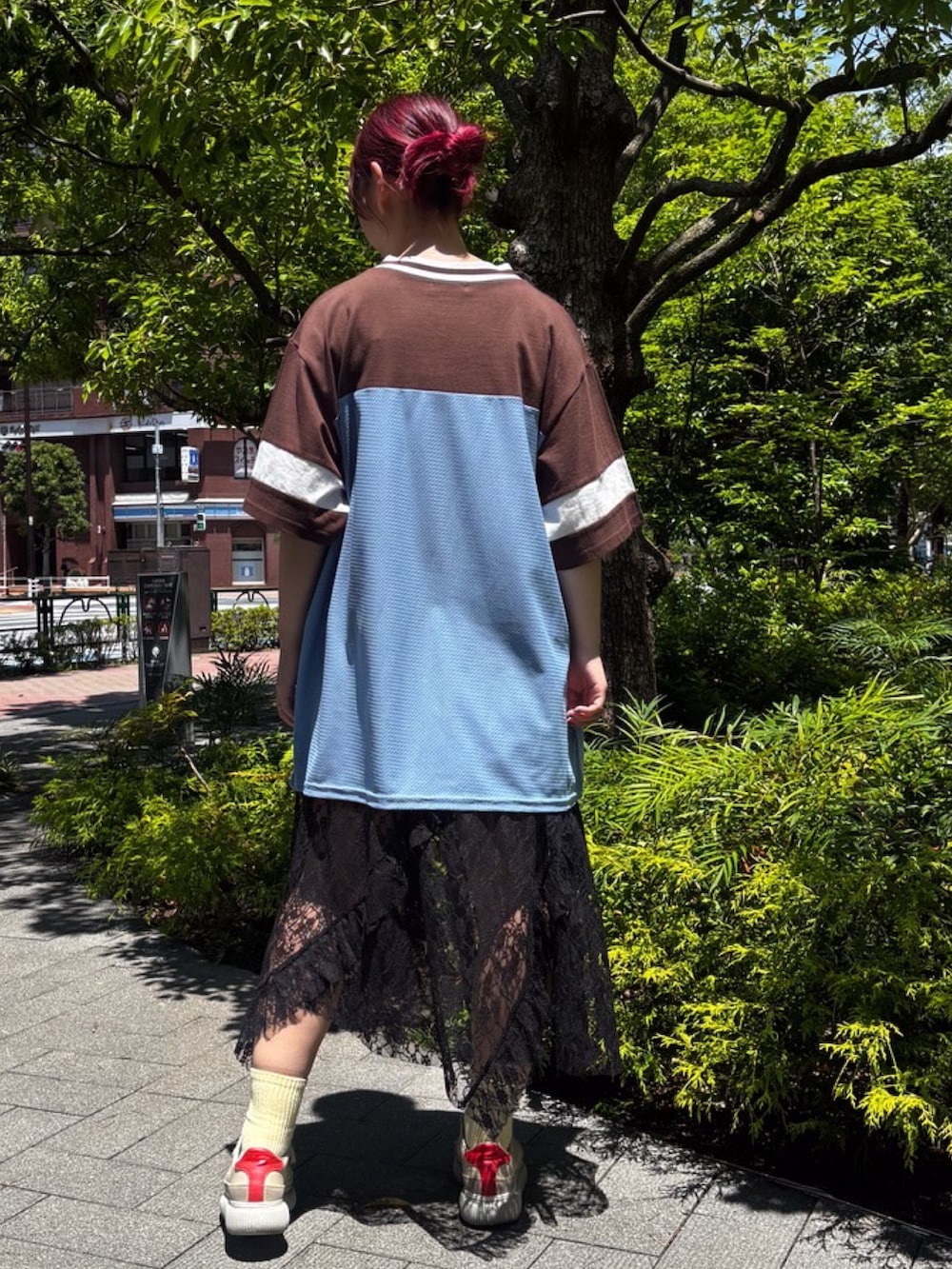 ブラウン系のTシャツ/カットソー、ブラック系のスカート、ブルー系のデニムパンツを着用したレディースの夏コーディネートの4枚目の写真