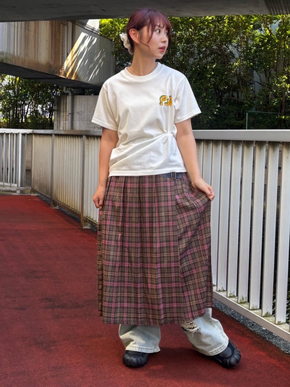 グリーン系のスカート、ホワイト系のTシャツ/カットソー、ブルー系のデニムパンツを着用したレディースの夏コーディネートの3枚目の写真