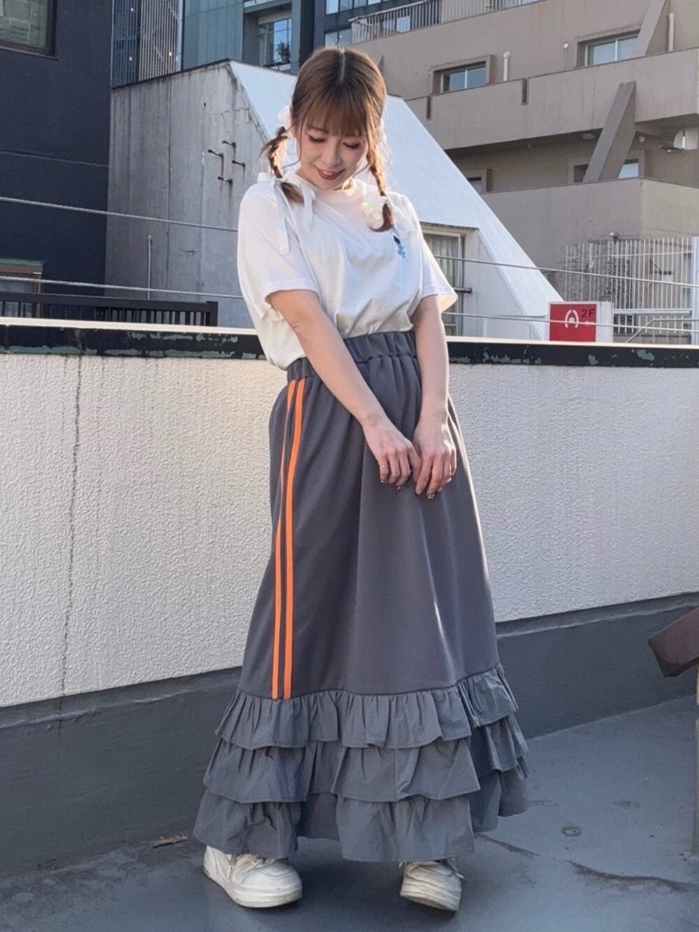 グレー系のスカート、ホワイト系のTシャツ/カットソーを着用したレディースの春コーディネートの2枚目の写真