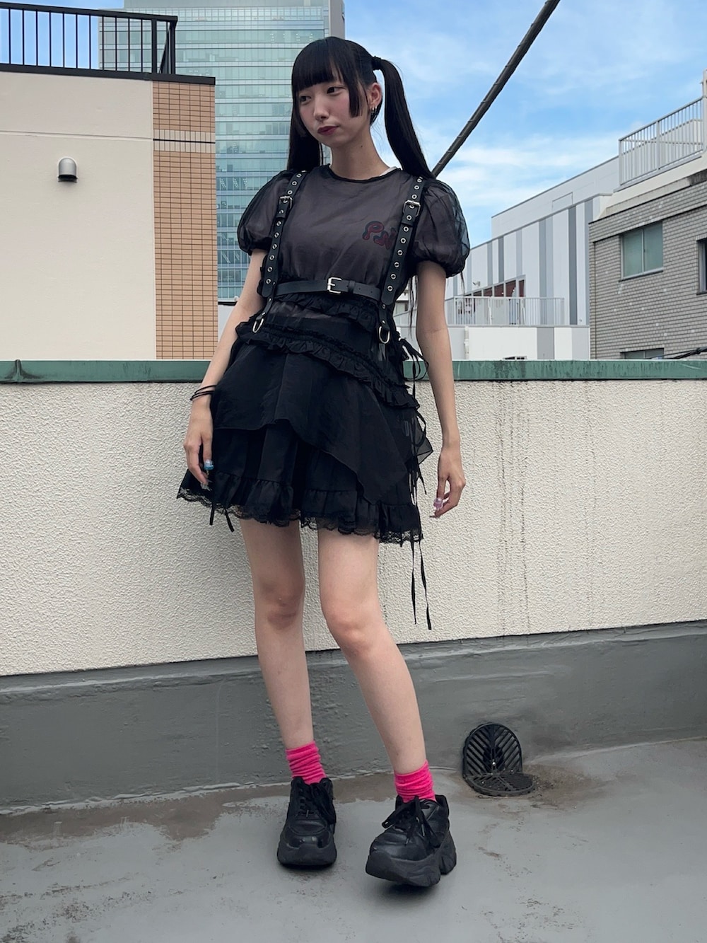 ブラック系のワンピース、ピンク系のTシャツ/カットソー、ブラック系のスカートを着用したレディースの夏コーディネートの2枚目の写真