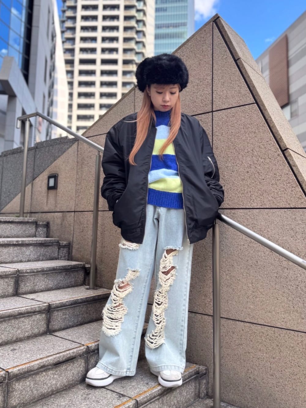 ブラック系のMA-1、ブルー系のニット/セーター、ブルー系のデニムパンツを着用したレディースの冬コーディネートの3枚目の写真