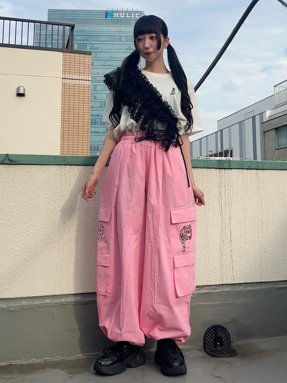 ピンク系のカーゴパンツ、ブラック系のスカート、ホワイト系のTシャツ/カットソーを着用したレディースの秋コーディネートの2枚目の写真