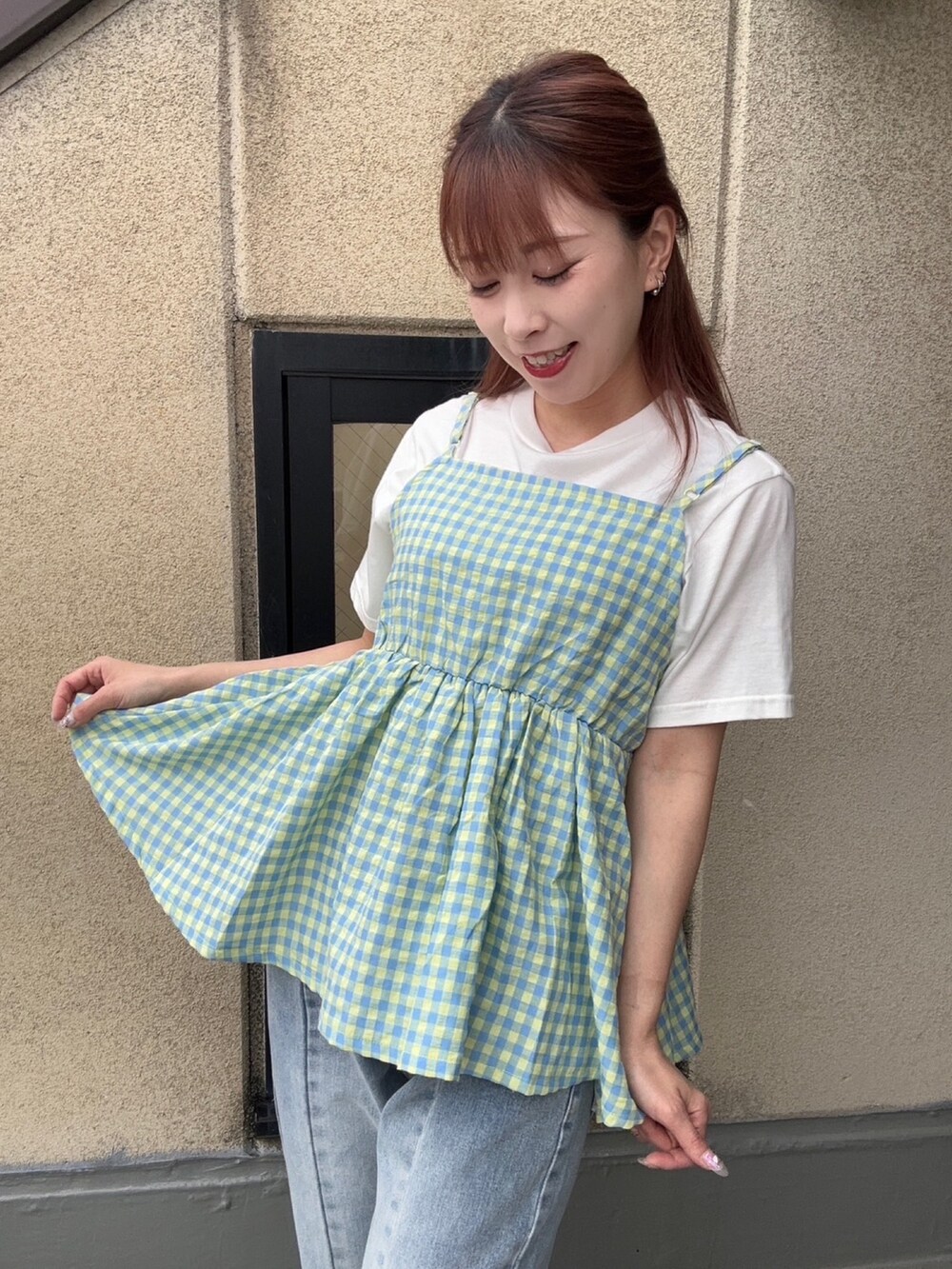 ブルー系のデニムパンツ、イエロー系のキャミソール、ホワイト系のTシャツ/カットソーを着用したレディースの夏コーディネートの2枚目の写真