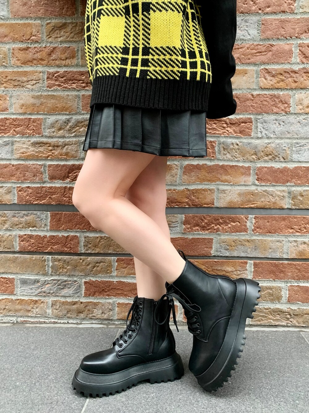 ブラック系のTシャツ/カットソー、イエロー系のベスト、ブラック系のスカートを着用したレディースの冬コーディネートの3枚目の写真