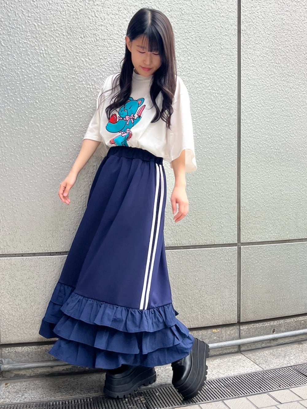 ブルー系のスカート、ホワイト系のTシャツ/カットソーを着用したレディースの春コーディネートの2枚目の写真