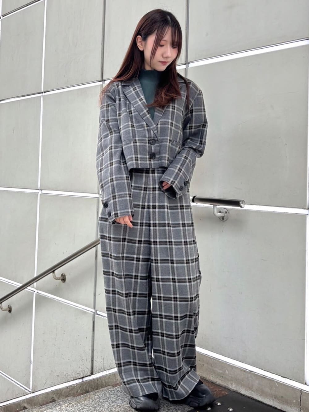 グレー系のスラックス、グレー系のテーラードジャケット、グリーン系のTシャツ/カットソーを着用したレディースの秋コーディネートの3枚目の写真