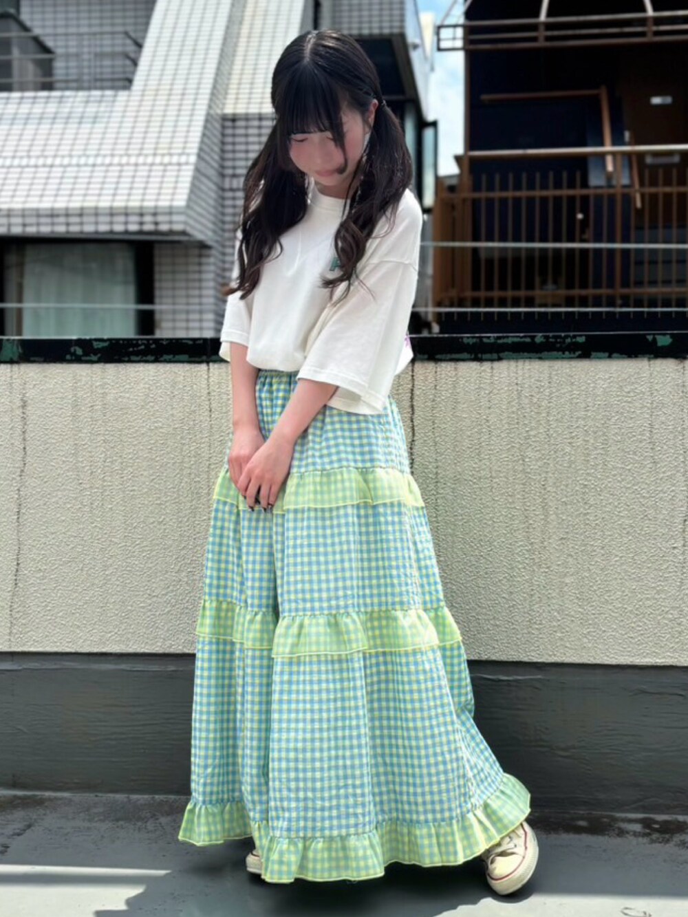 イエロー系のスカート、ホワイト系のTシャツ/カットソーを着用したレディースの夏コーディネートの2枚目の写真