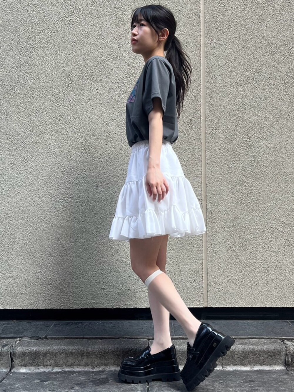 ホワイト系のスカート、ブラック系のTシャツ/カットソーを着用したレディースの夏コーディネートの2枚目の写真