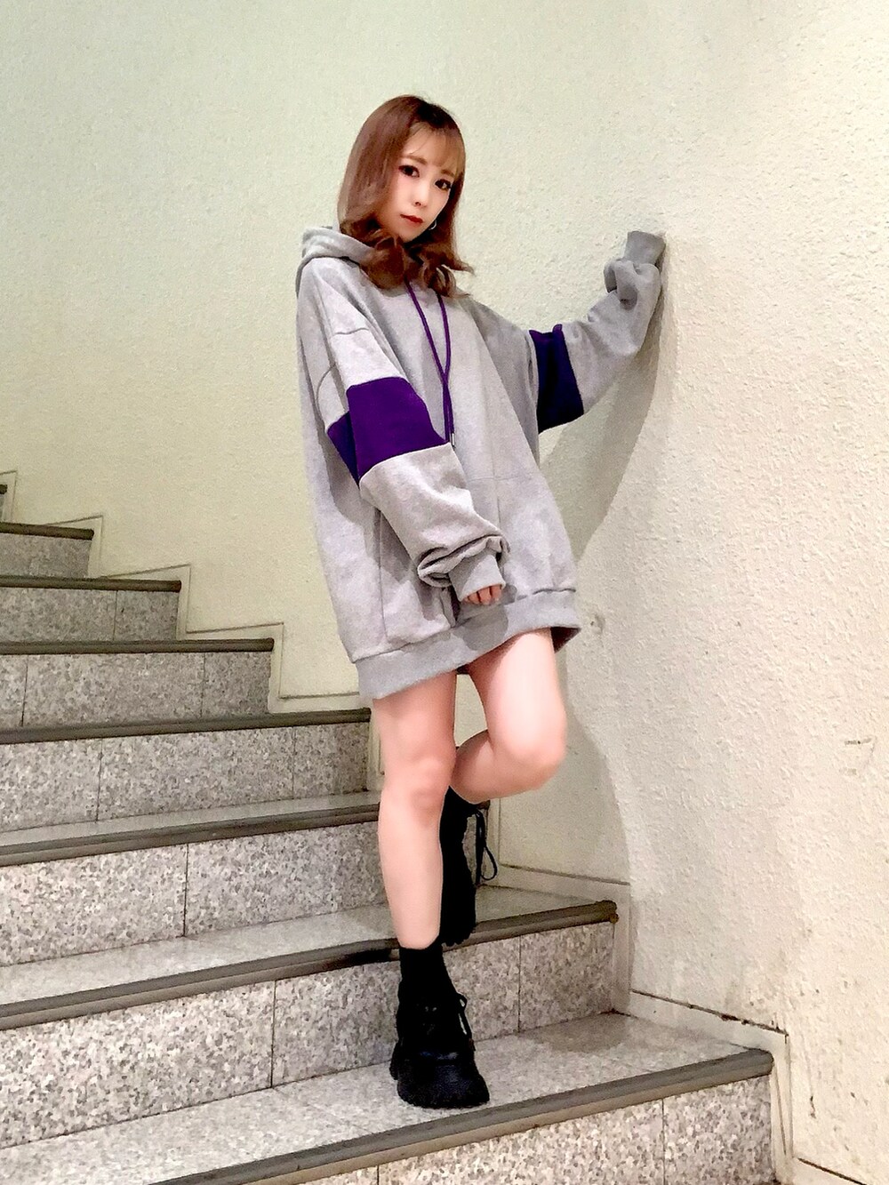 グレー系のパーカー、ブルー系のデニムジャケット、ブラック系のブーツを着用したレディースの冬コーディネートの2枚目の写真