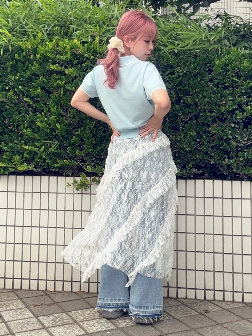 ホワイト系のスカート、ブルー系のポロシャツ、ブルー系のデニムパンツを着用したレディースの夏コーディネートの4枚目の写真