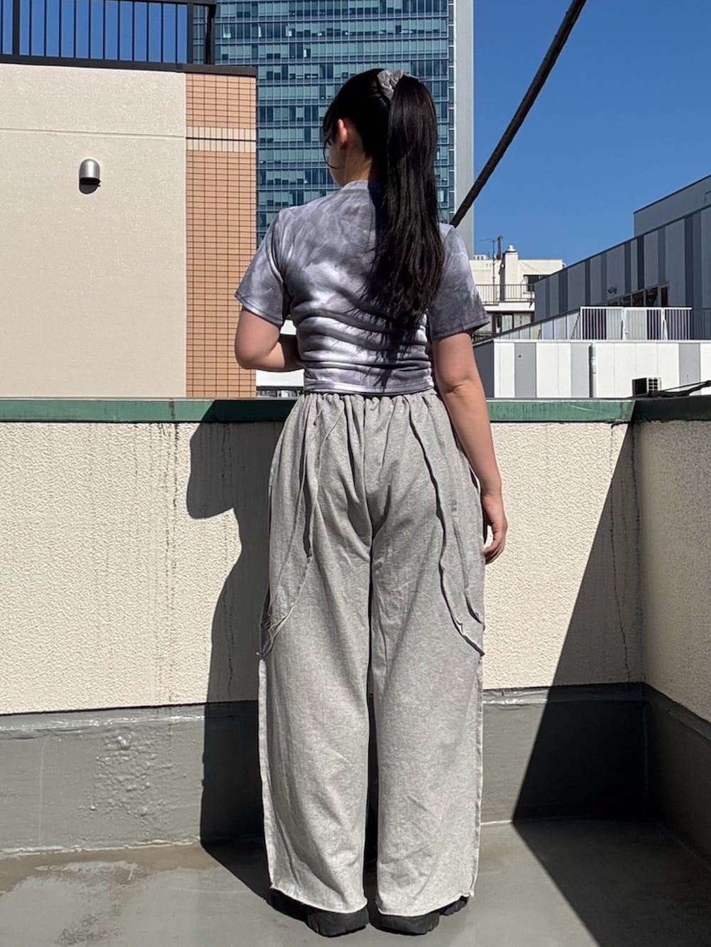 グレー系のスウェットパンツ、パープル系のTシャツ/カットソーを着用したレディースの夏コーディネートの7枚目の写真