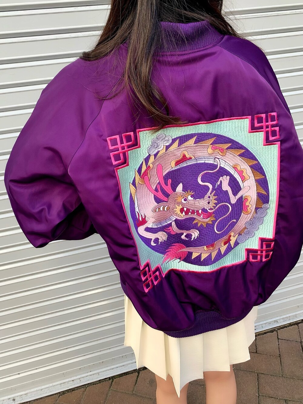 ブラック系のTシャツ/カットソー、パープル系のブルゾン、ホワイト系のスカートを着用したレディースの冬コーディネートの4枚目の写真