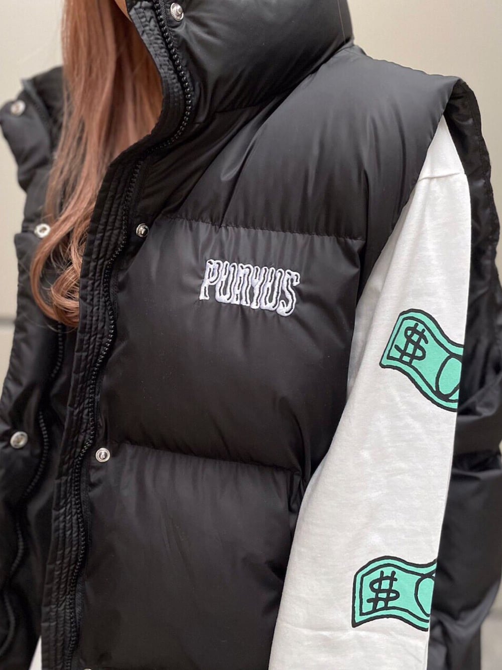 ホワイト系のTシャツ/カットソー、ブラック系のダウンベストを着用したレディースの冬コーディネートの2枚目の写真