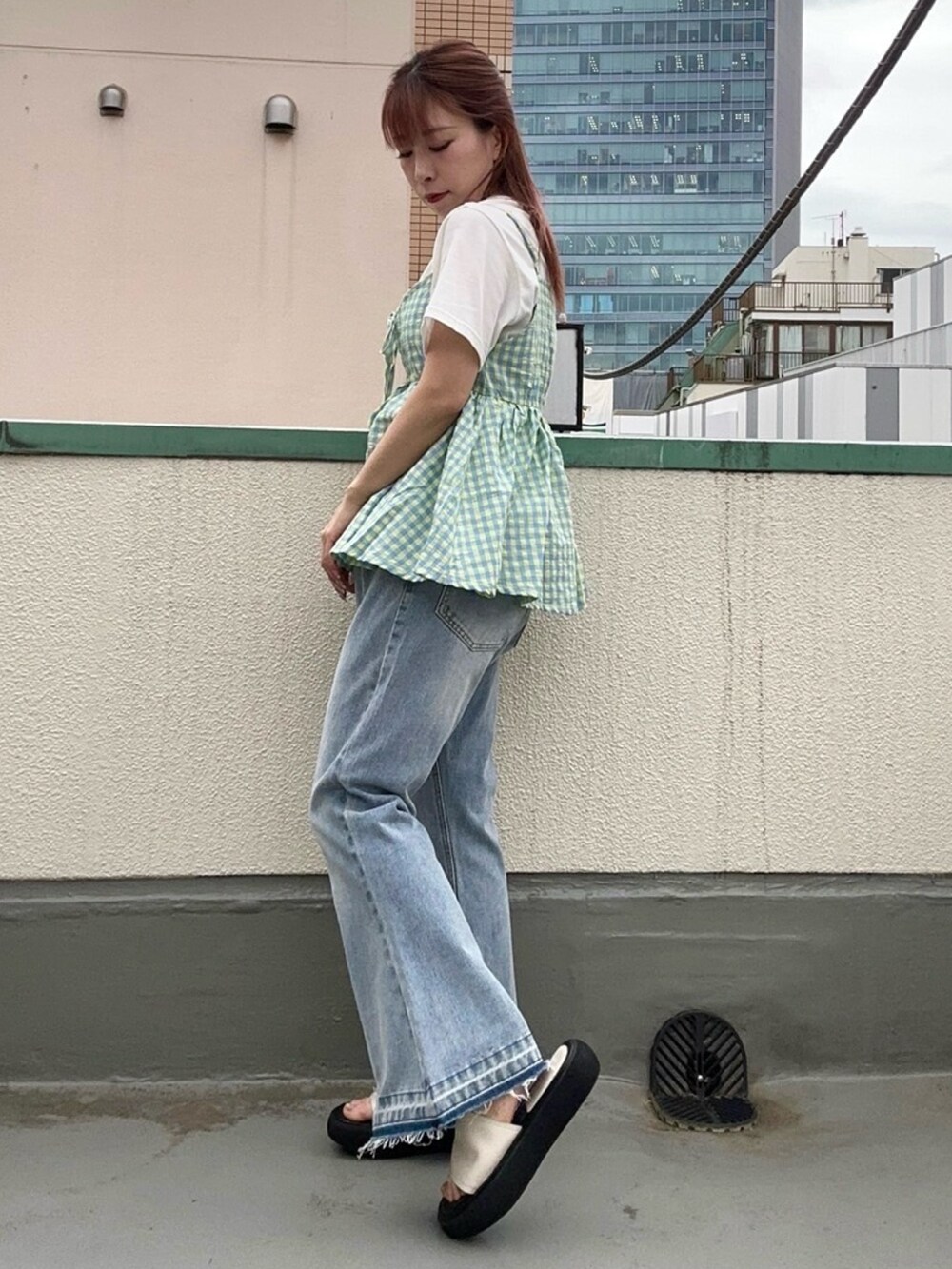 ブルー系のデニムパンツ、イエロー系のキャミソール、ホワイト系のTシャツ/カットソーを着用したレディースの夏コーディネートの4枚目の写真