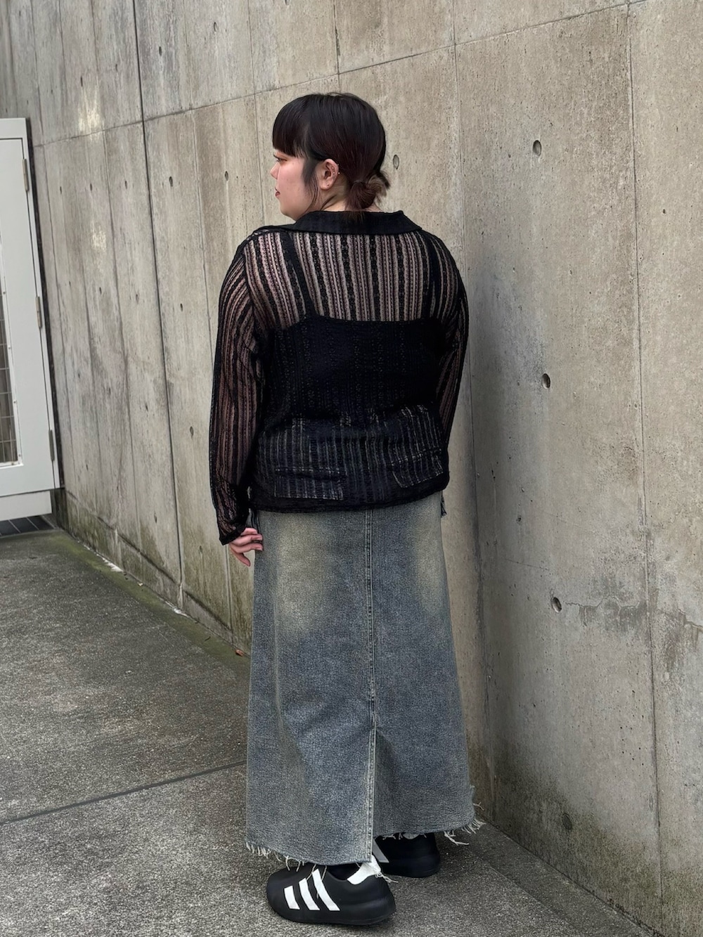 ブラック系のカーディガン/ボレロ、ブルー系のデニムスカートを着用したレディースの夏コーディネートの3枚目の写真