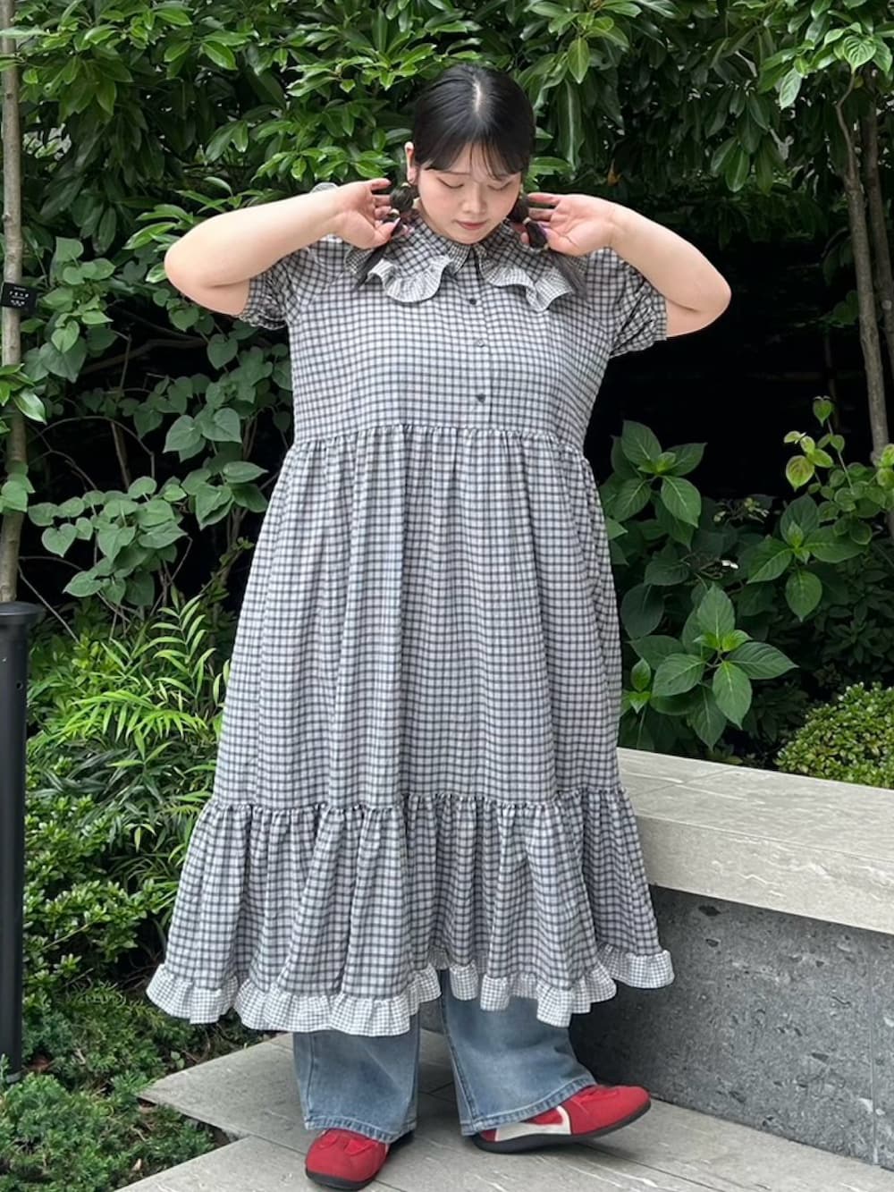 ブラック系のワンピース、ブルー系のデニムパンツを着用したレディースの夏コーディネートの6枚目の写真