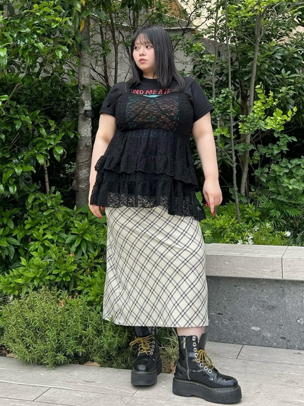 ベージュ系のスカート、ブラック系のワンピース、ブラック系のTシャツ/カットソーを着用したレディースの春コーディネートの2枚目の写真