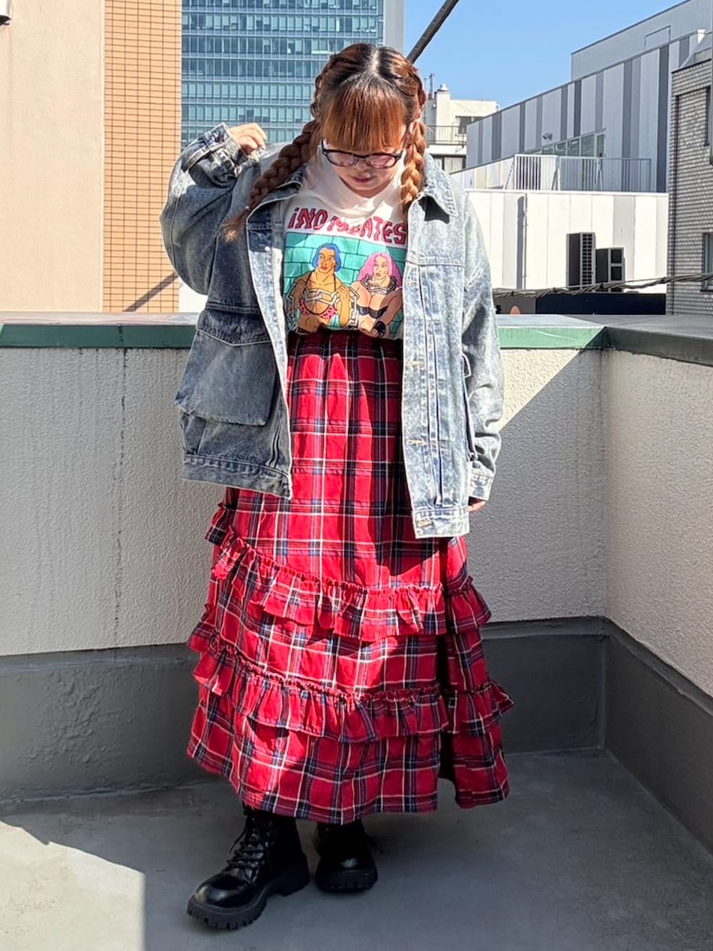 レッド系のスカート、ブルー系のデニムジャケット、ホワイト系のTシャツ/カットソーを着用したレディースの秋コーディネートの2枚目の写真