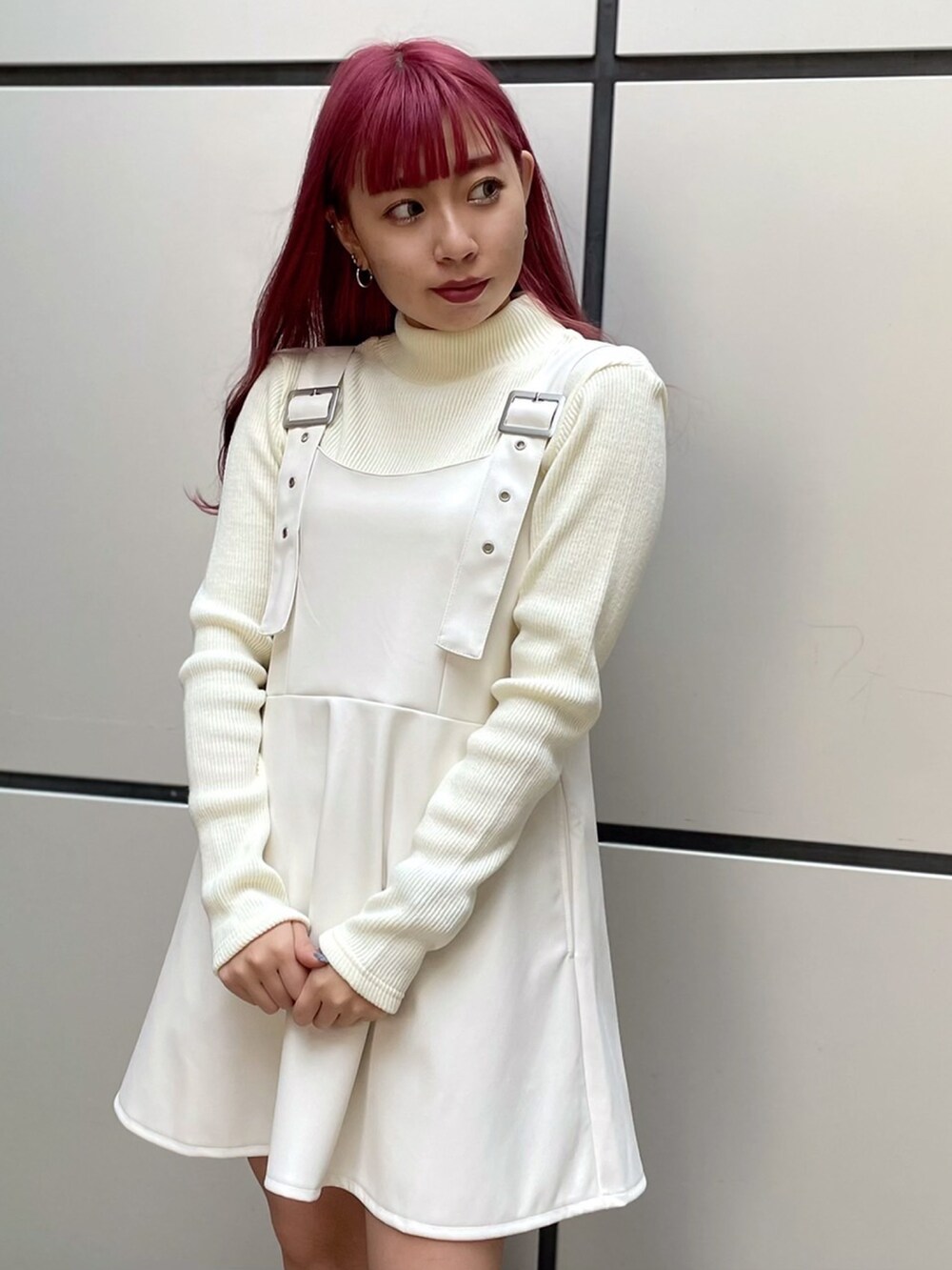 ホワイト系のニット/セーター、ホワイト系のジャンパースカートを着用したレディースの秋コーディネートの2枚目の写真