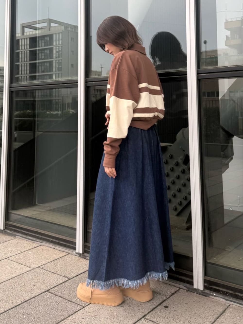 ブルー系のスカート、ブラウン系のスウェットを着用したレディースの春コーディネートの3枚目の写真