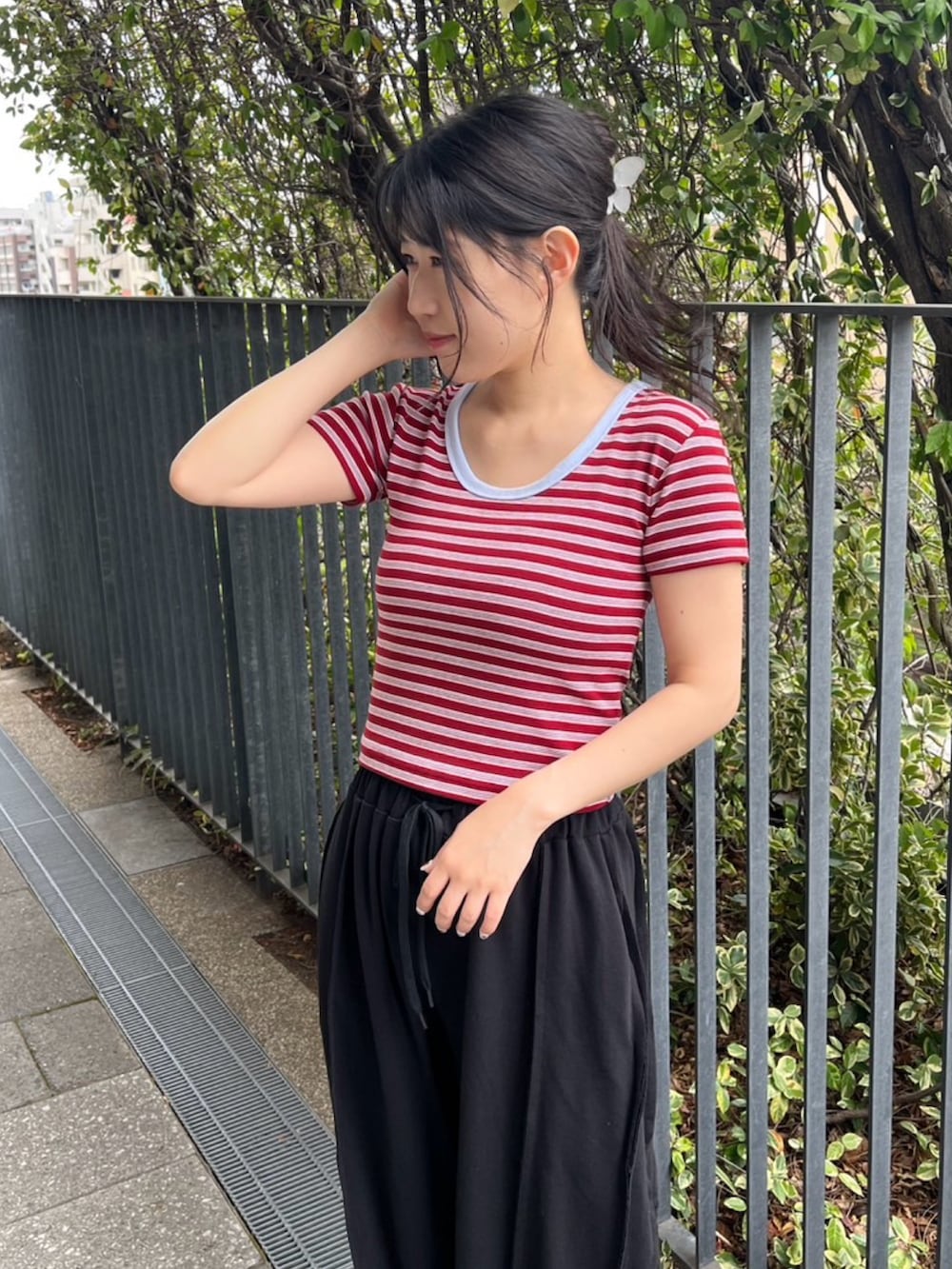 ブラック系のスウェットパンツ、レッド系のTシャツ/カットソーを着用したレディースの夏コーディネートの4枚目の写真