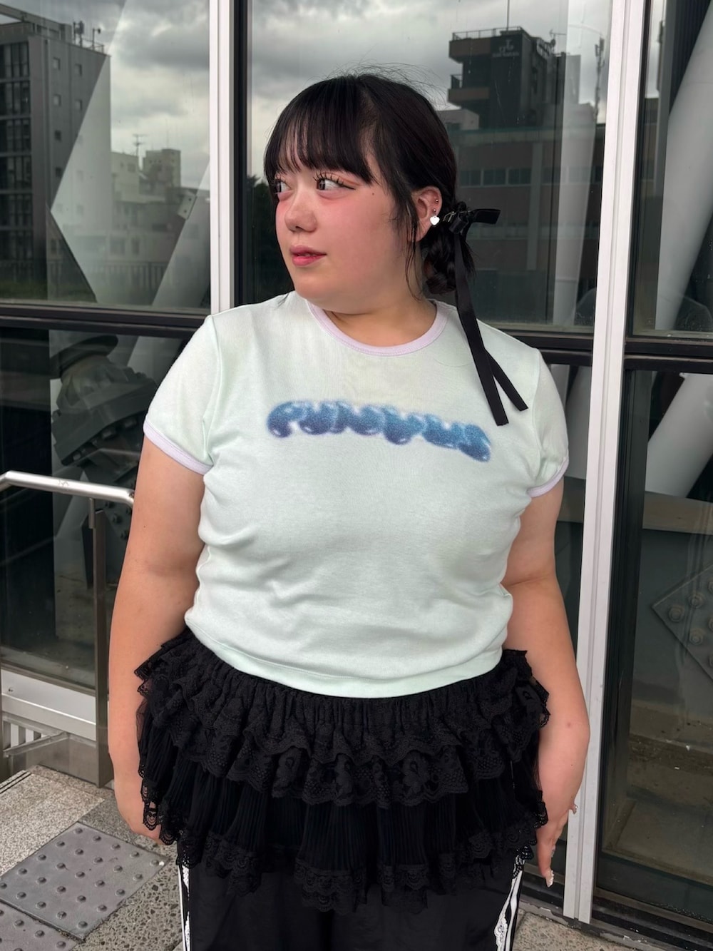 グリーン系のTシャツ/カットソー、ブラック系のスカート、ブラック系のその他パンツを着用したレディースの夏コーディネートの2枚目の写真
