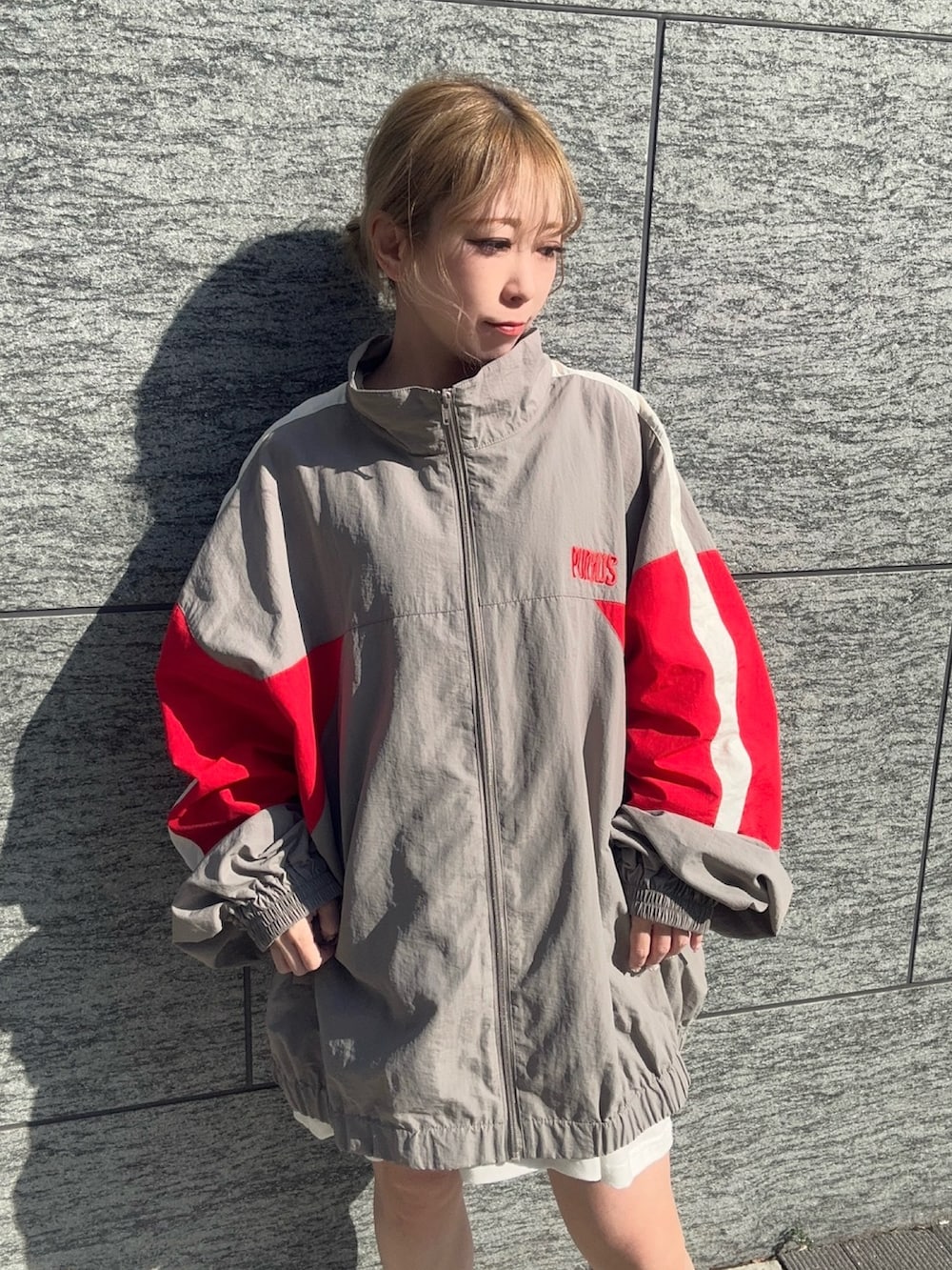 グレー系のナイロンジャケット、ホワイト系のTシャツ/カットソーを着用したレディースの春コーディネートの3枚目の写真