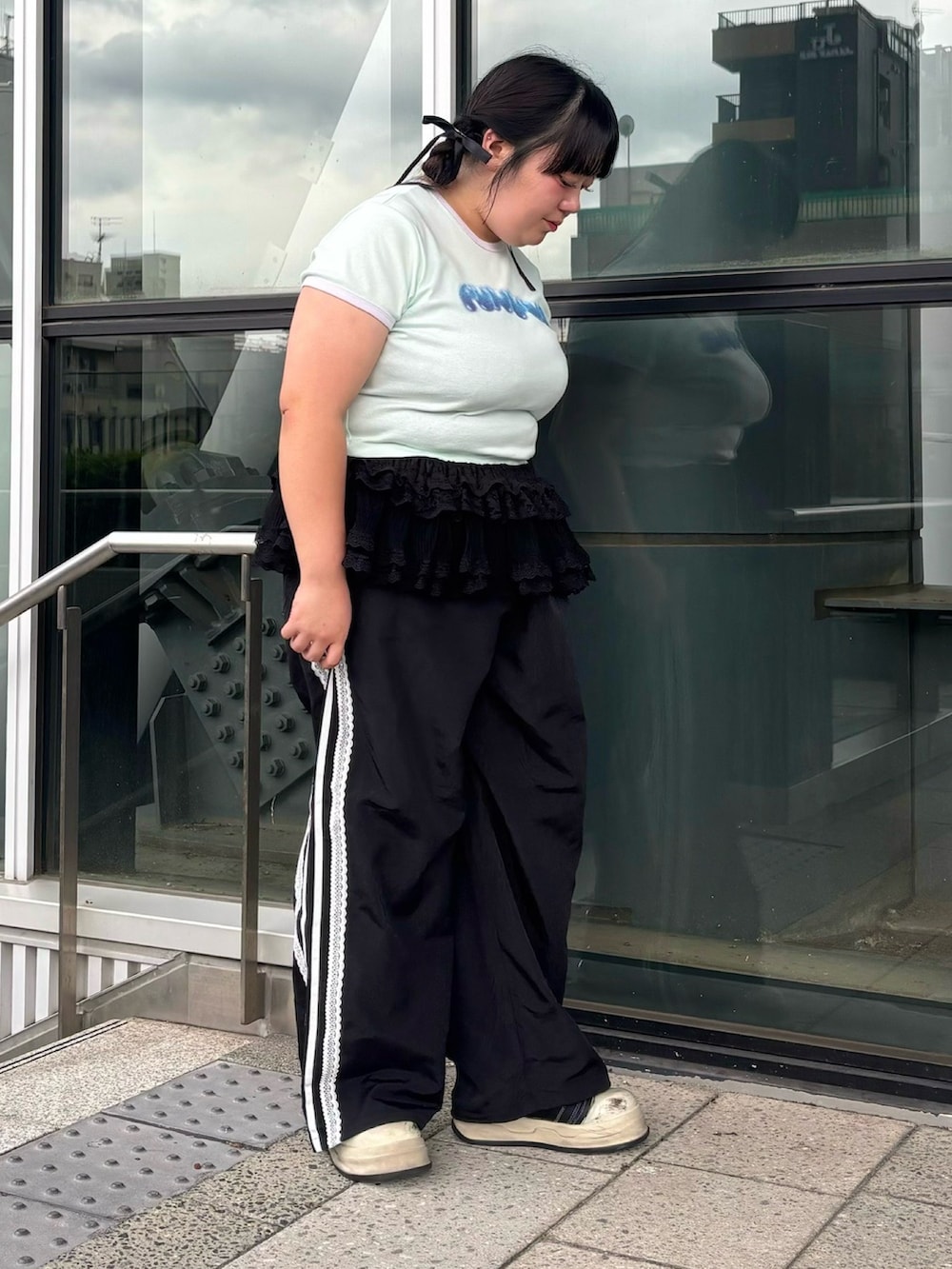 グリーン系のTシャツ/カットソー、ブラック系のスカート、ブラック系のその他パンツを着用したレディースの夏コーディネートの4枚目の写真