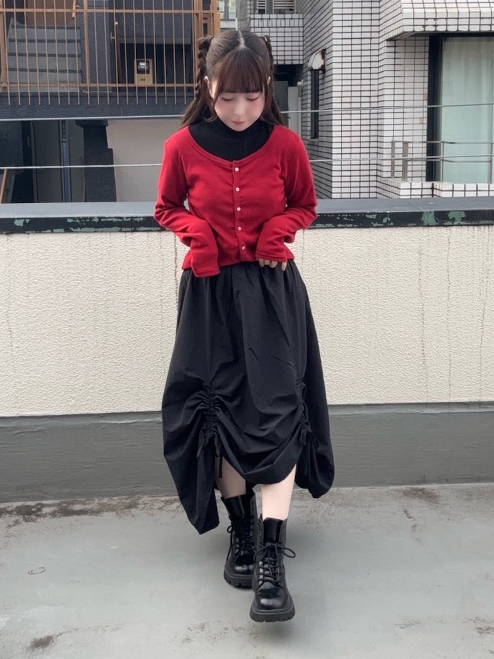 ブラック系のスカート、レッド系のカーディガン/ボレロ、ブラック系のTシャツ/カットソーを着用したレディースの秋コーディネートの2枚目の写真