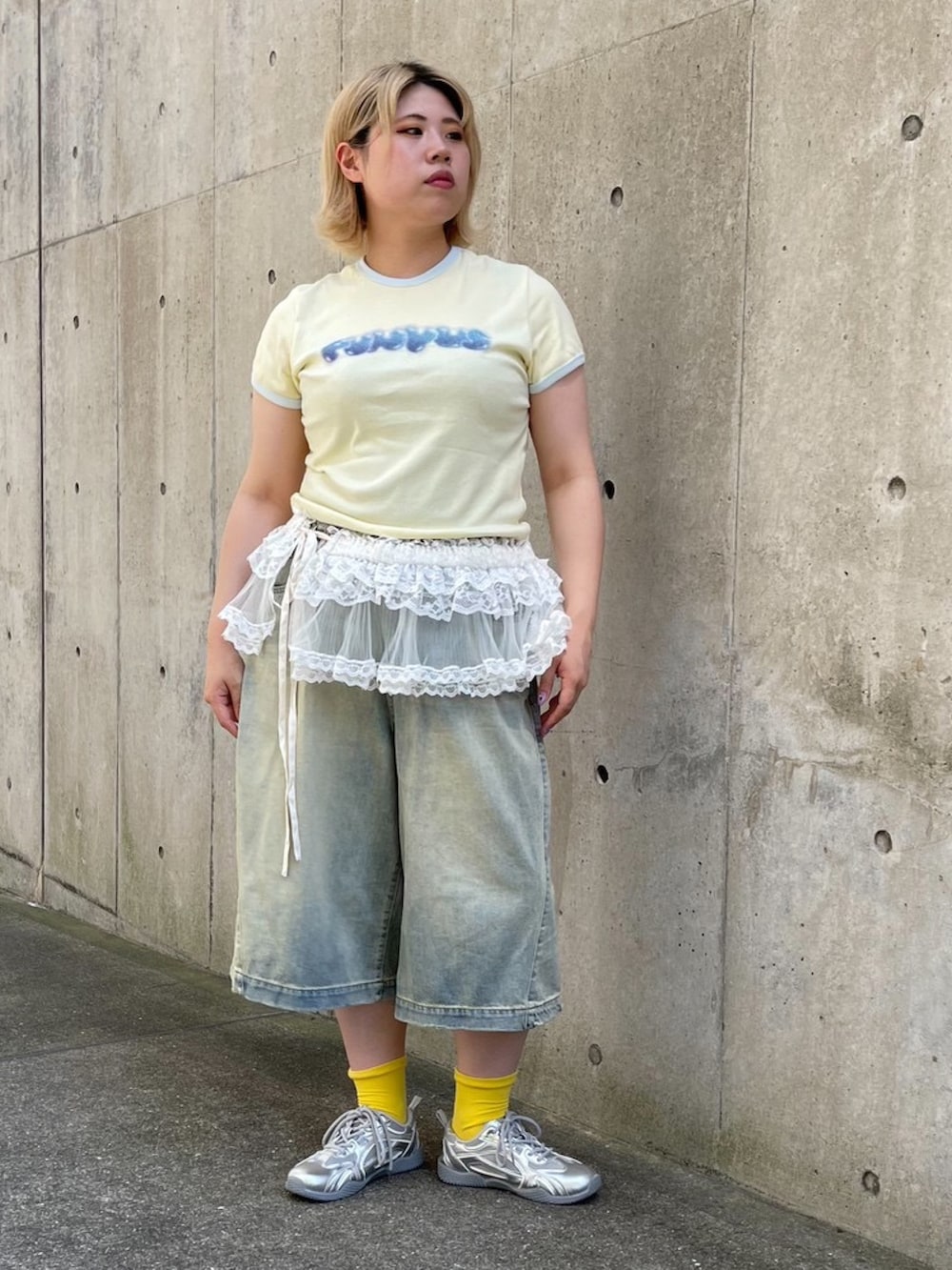 ブルー系のデニムパンツ、ホワイト系のスカート、イエロー系のTシャツ/カットソーを着用したレディースの夏コーディネートの3枚目の写真