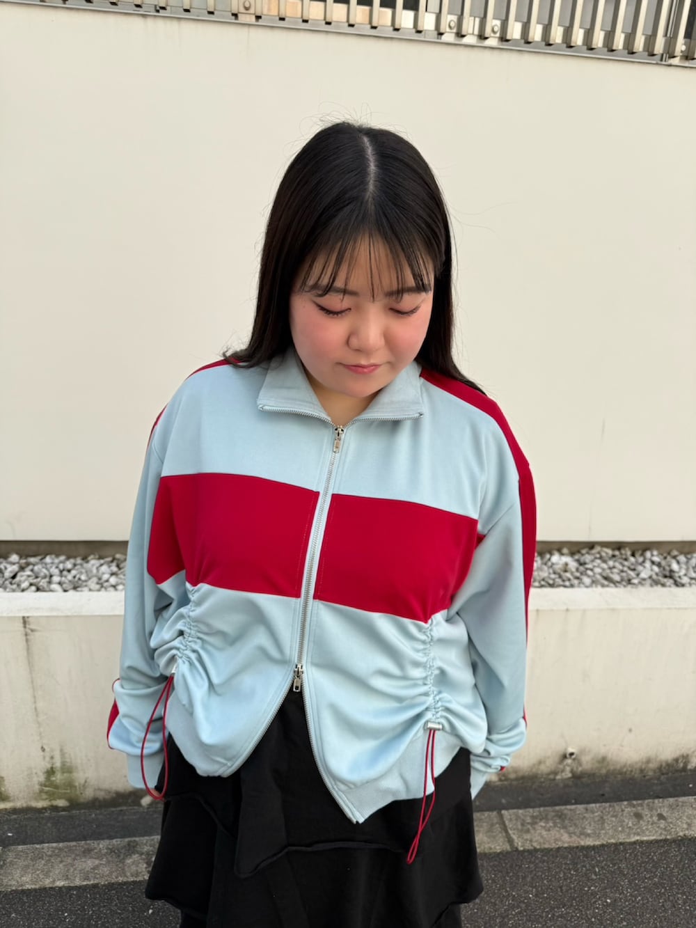 ブラック系のスカート、ブルー系のジャージを着用したレディースの春コーディネートの4枚目の写真