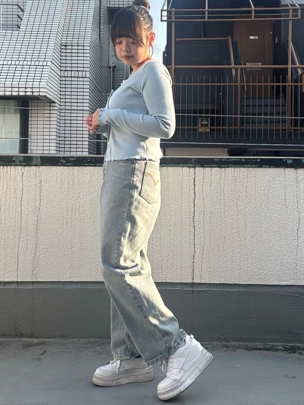 ブルー系のデニムパンツ、ブルー系のカーディガン/ボレロを着用したレディースの春コーディネートの4枚目の写真