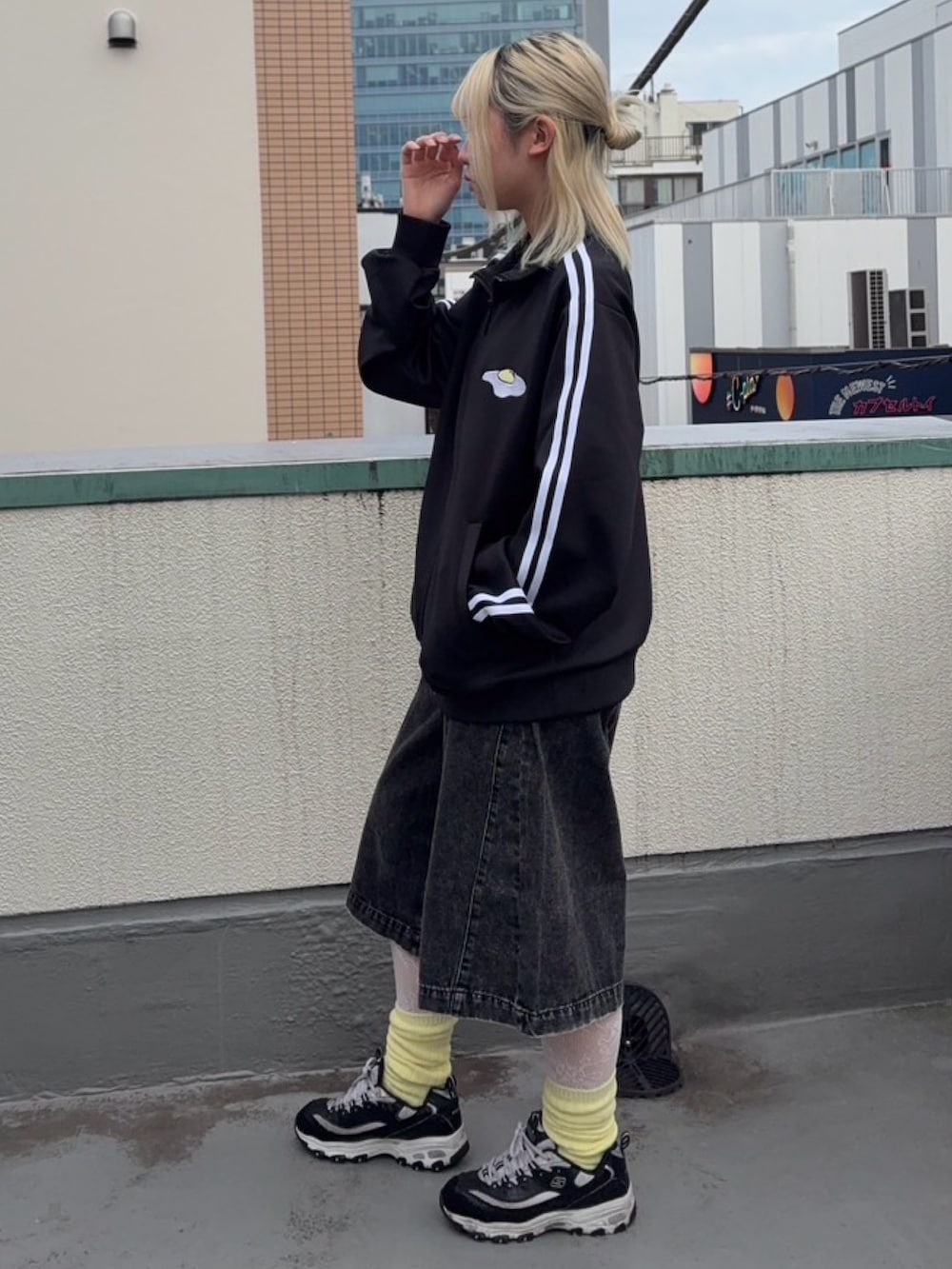 ブラック系のジャージ、ブラック系のデニムパンツ、イエロー系のソックス/靴下を着用したレディースの秋コーディネートの4枚目の写真