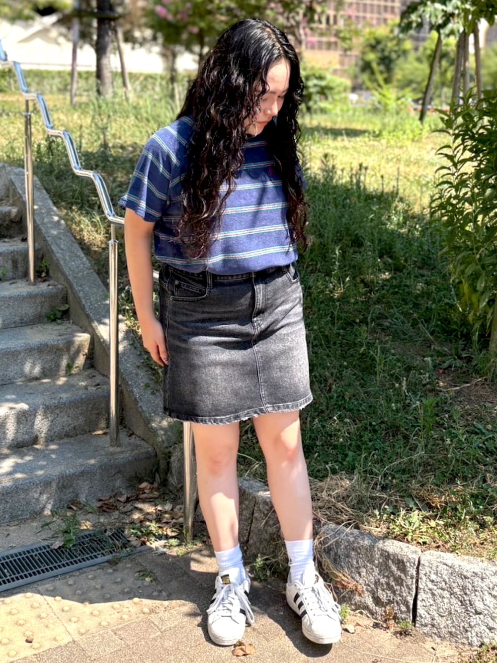 ブラック系のデニムスカート、ブルー系のTシャツ/カットソーを着用したレディースの夏コーディネートの2枚目の写真