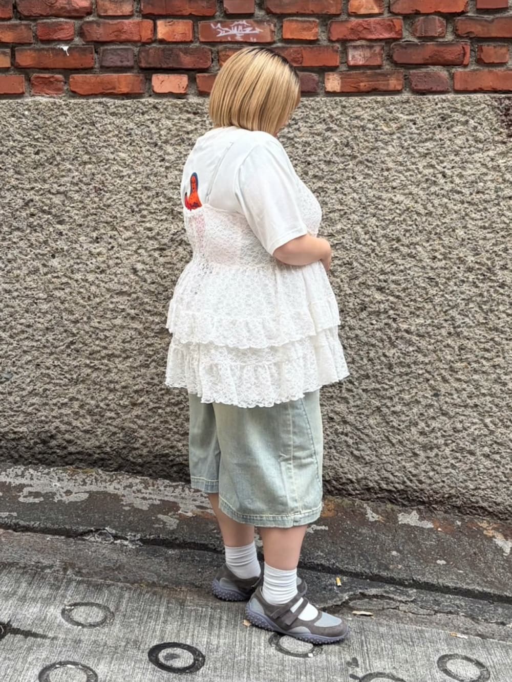 ブルー系のデニムパンツ、ホワイト系のTシャツ/カットソー、ホワイト系のワンピースを着用したレディースの春コーディネートの3枚目の写真