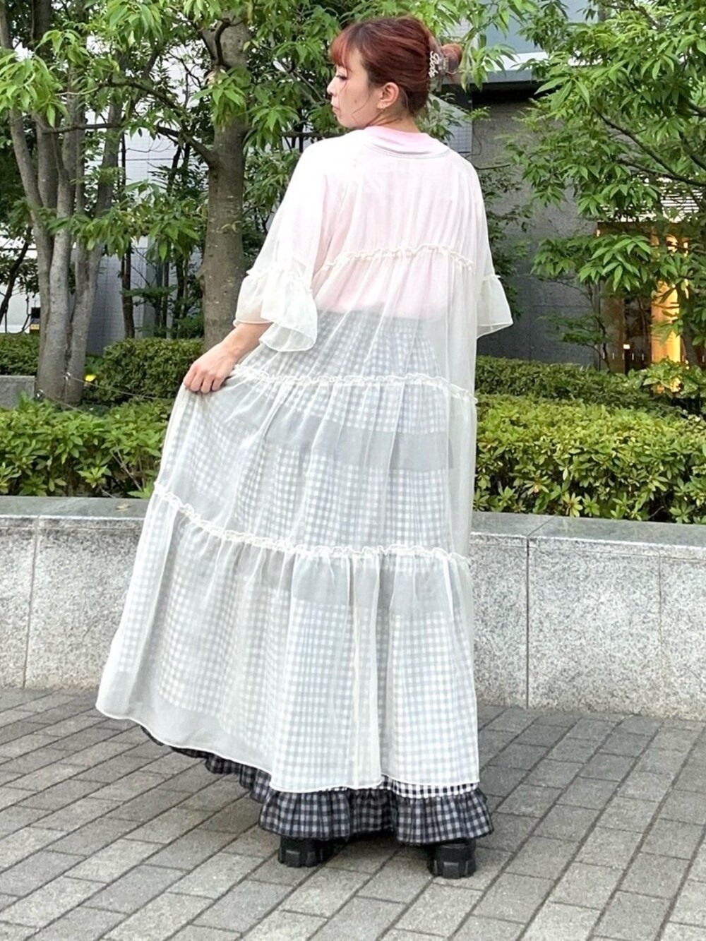 ブラック系のスカート、ホワイト系のワンピース、ピンク系のTシャツ/カットソーを着用したレディースの夏コーディネートの2枚目の写真