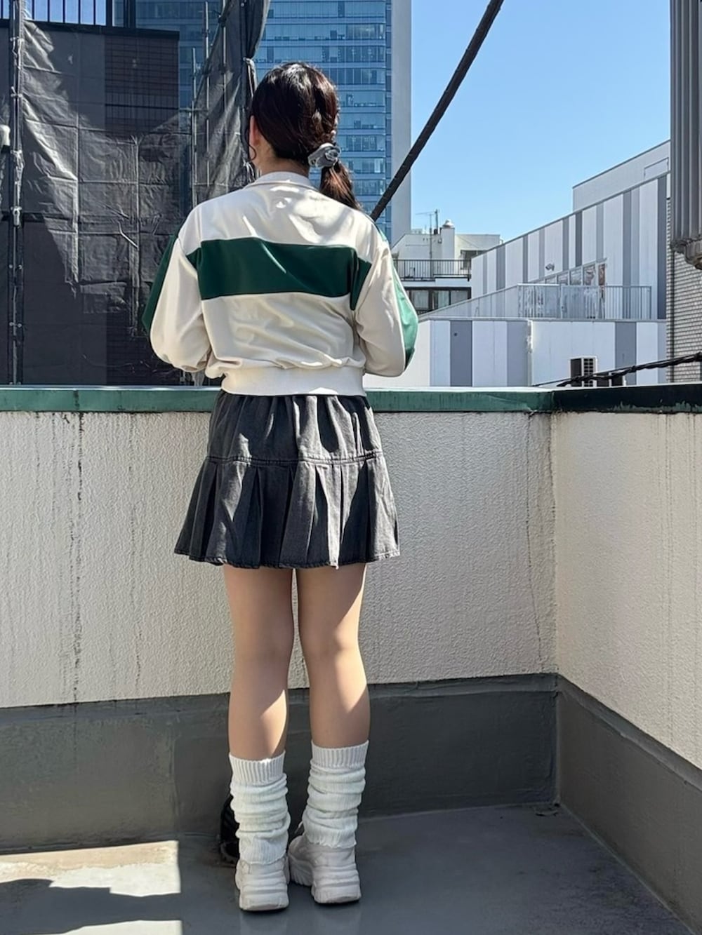 ブラック系のデニムスカート、ホワイト系のジャージを着用したレディースの春コーディネートの4枚目の写真