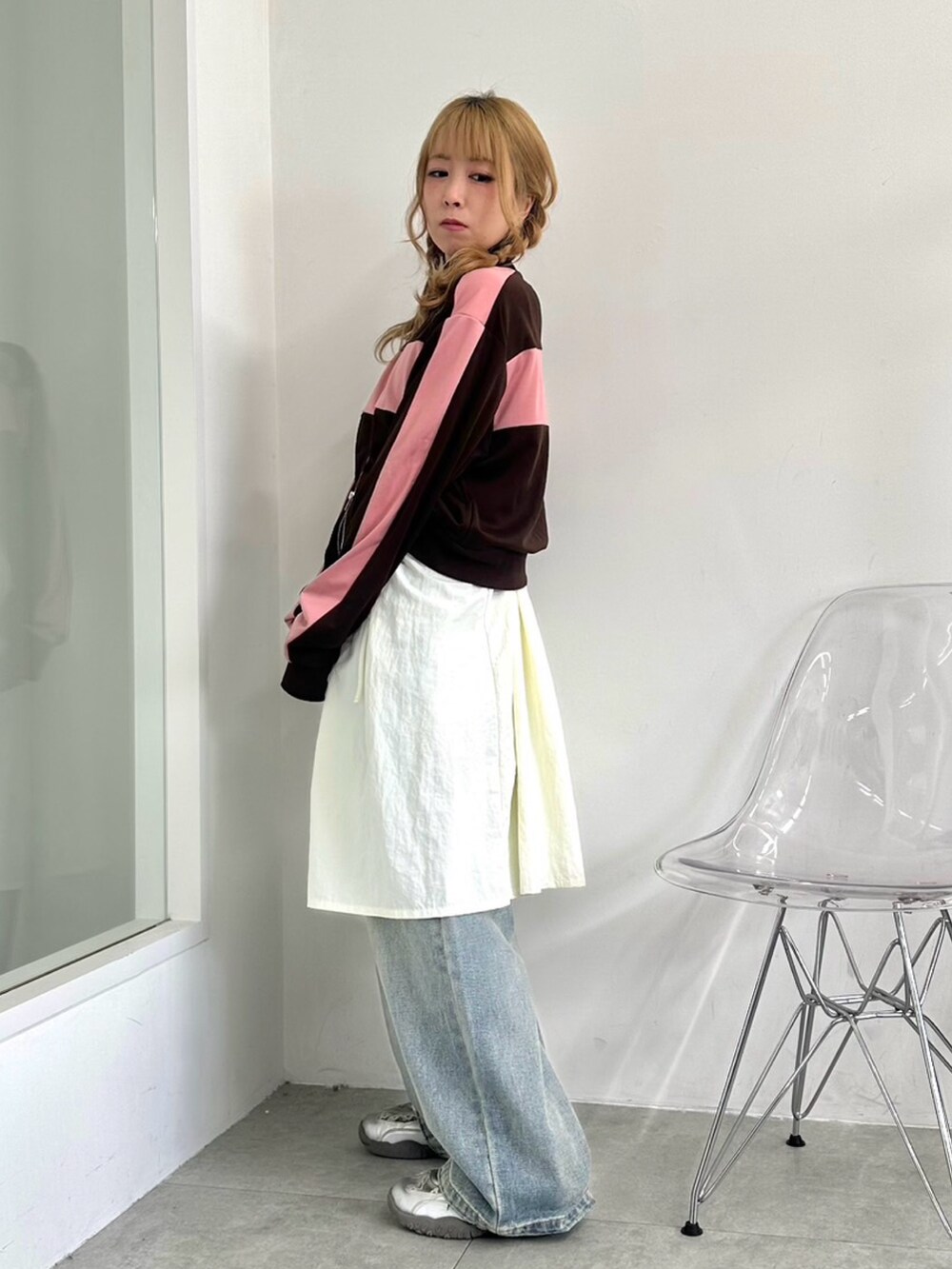 ホワイト系のワンピース、ブラウン系のジャージ、ブルー系のデニムパンツを着用したレディースの秋コーディネートの3枚目の写真