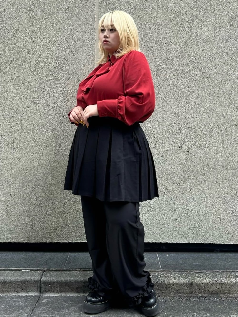 レッド系のシャツ/ブラウス、ブラック系のスカート、ブラック系のスラックスを着用したレディースの秋コーディネートの3枚目の写真