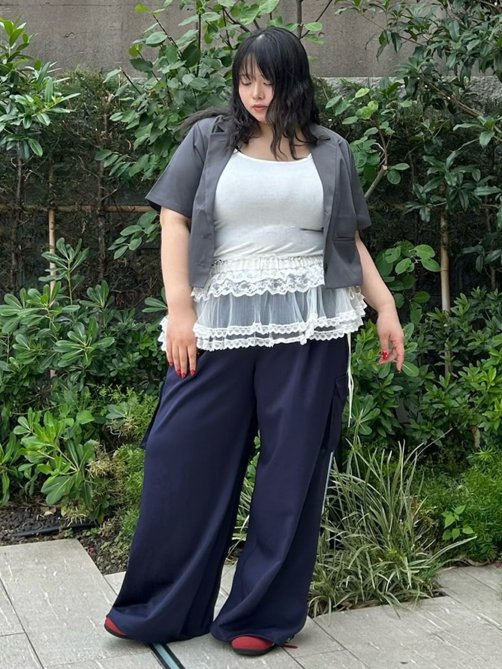 ブルー系のカーゴパンツ、グレー系のテーラードジャケット、ホワイト系のスカートを着用したレディースの夏コーディネートの2枚目の写真