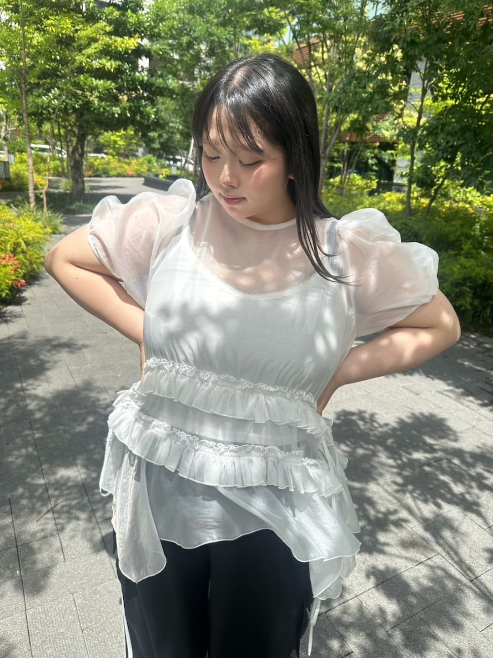 ブラック系のカーゴパンツ、ホワイト系のワンピース、ホワイト系のキャミソールを着用したレディースの夏コーディネートの5枚目の写真