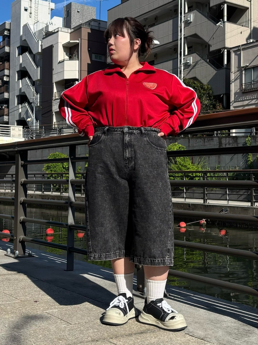 ブラック系のデニムパンツ、レッド系のジャージを着用したレディースの夏コーディネートの3枚目の写真