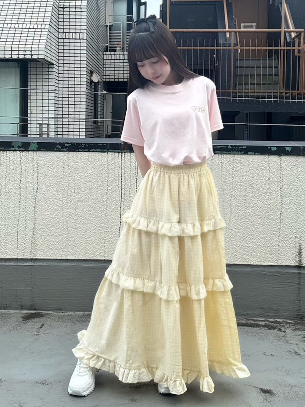 イエロー系のスカート、ピンク系のTシャツ/カットソーを着用したレディースの夏コーディネートの2枚目の写真