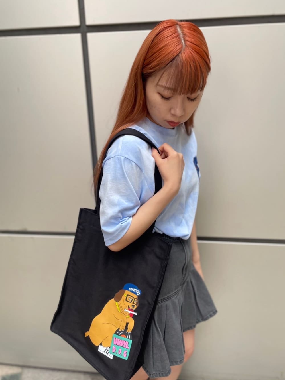 ブルー系のTシャツ/カットソー、ブラック系のトートバッグ、ブラック系のデニムスカートを着用したレディースの夏コーディネートの3枚目の写真