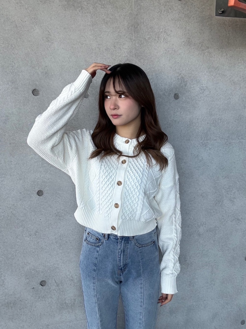 ブルー系のデニムパンツ、ホワイト系のカーディガン/ボレロを着用したレディースの冬コーディネートの3枚目の写真