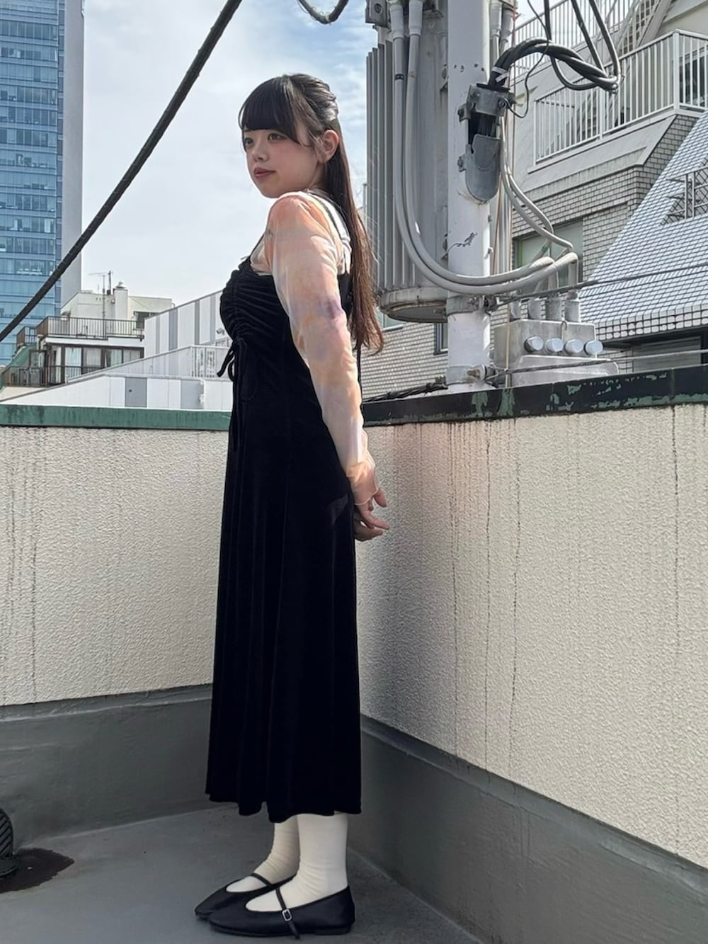 ブラック系のワンピース、オレンジ系のTシャツ/カットソーを着用したレディースの春コーディネートの4枚目の写真