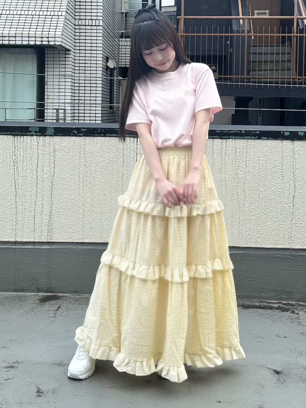 イエロー系のスカート、ピンク系のTシャツ/カットソーを着用したレディースの夏コーディネートの3枚目の写真